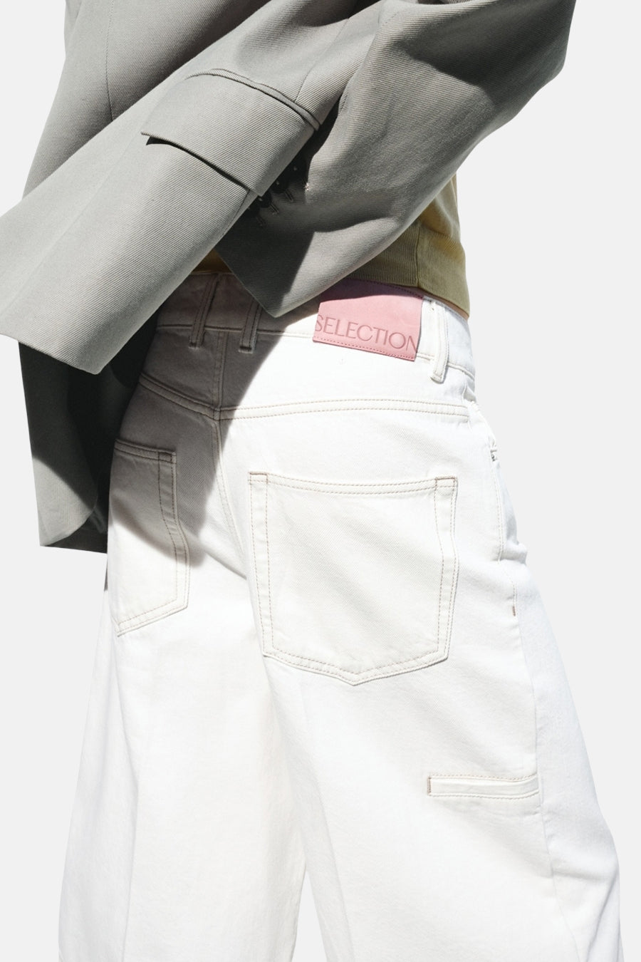 Witte Bermuda van MANGO met roze 'SELECTION' label, achterzakken en zijzakje, gedragen met blazer.