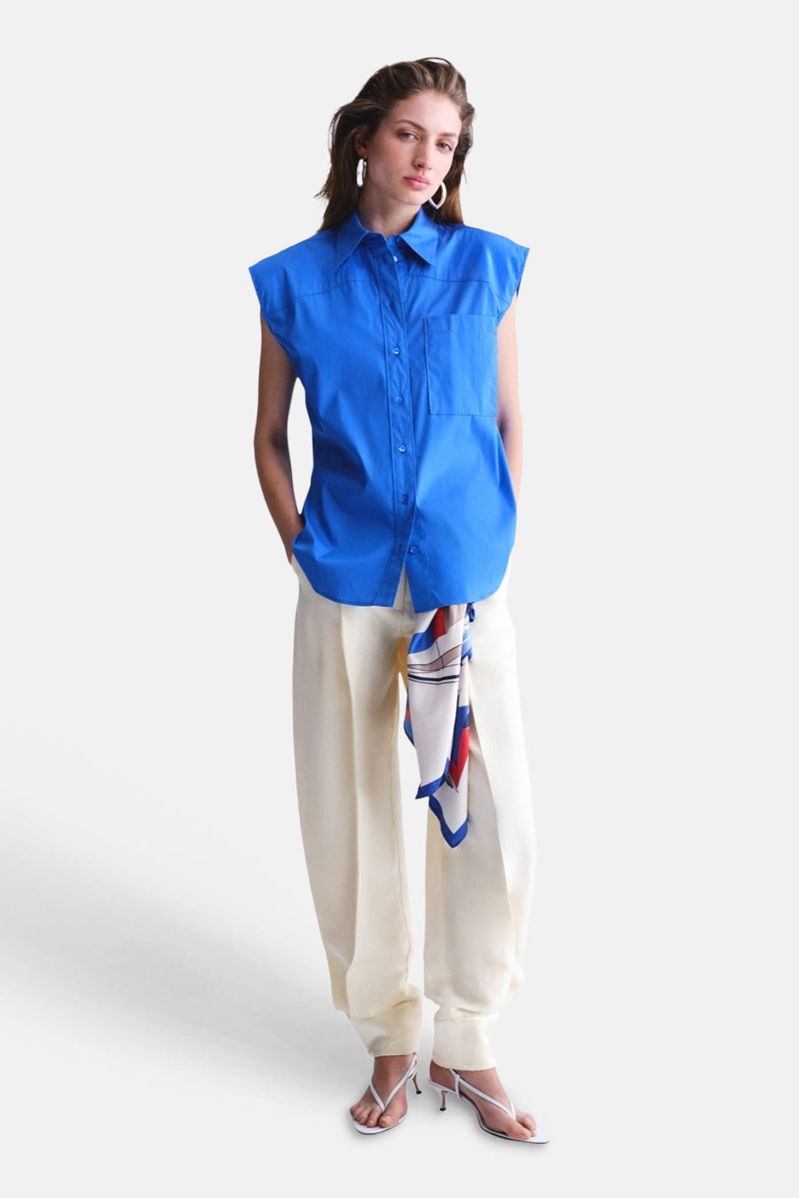 Blauw mouwloos hemd van MANGO met kraag en zakken, gecombineerd met crèmekleurige broek.