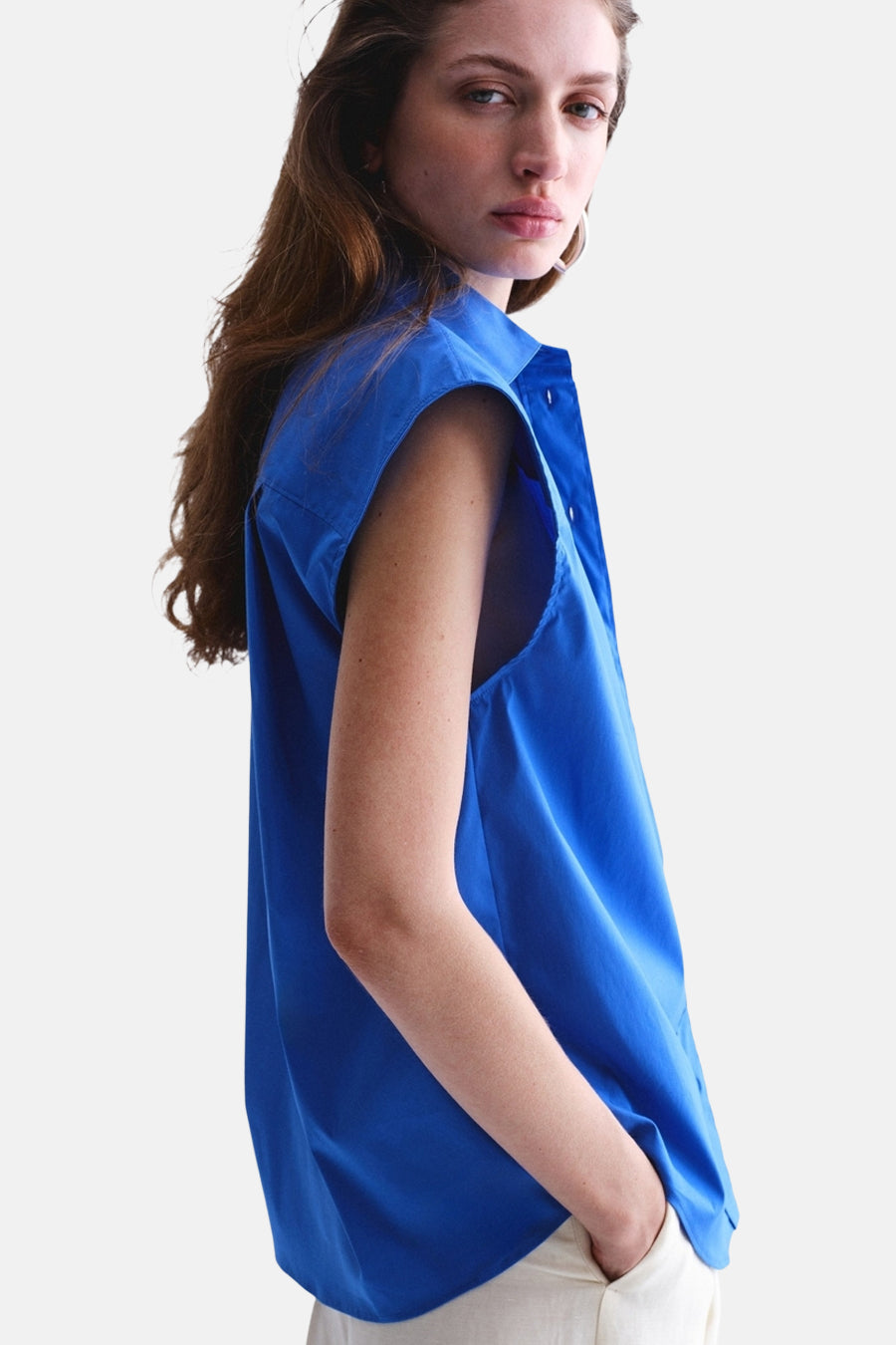 Blauw mouwloos hemd van MANGO, gedragen door een model met de hand in de zak.