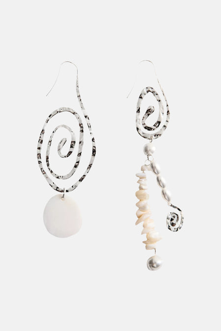 Asymmetrische zilverkleurige oorringen van MANGO met gehamerde spiralen, witte schelpstukjes en parels.