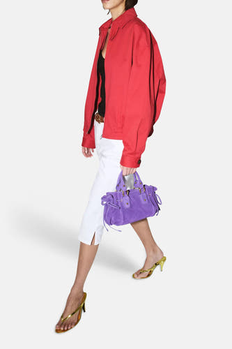 Witte 5-pocket broek van MANGO, capri-lengte met splitjes, gestyled met een rood jack en paarse tas.