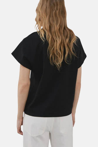 Zwarte top van MANGO, gezien van achteren, met korte mouwen en gedragen met een witte broek.
