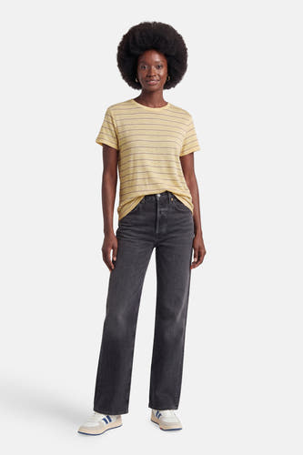 Geel gestreept T-shirt van MANGO, gedragen door een model met donkere jeans en sneakers.