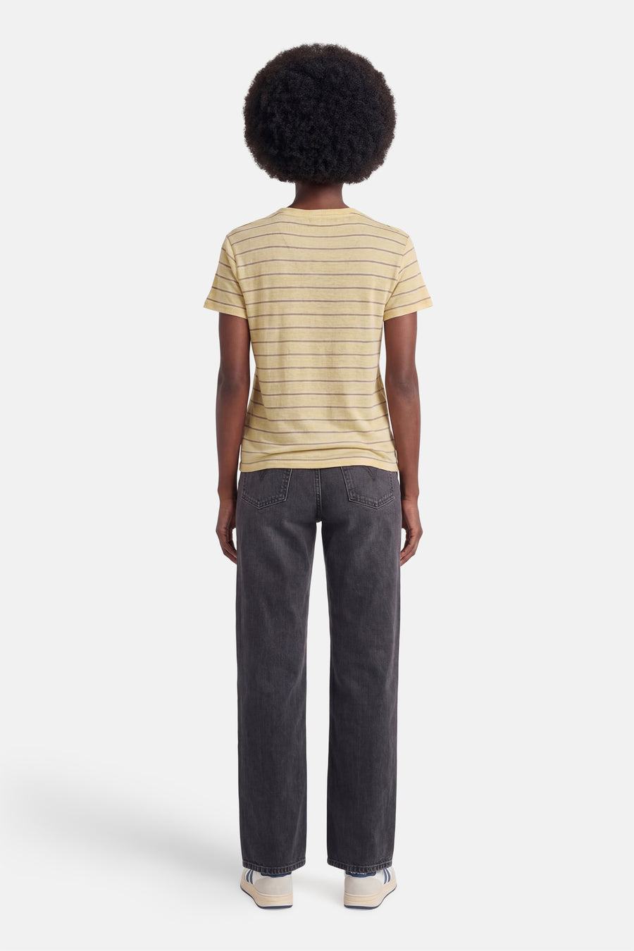 Geel T-shirt van MANGO met horizontale strepen, van achteren gezien, gecombineerd met een donkere jeans en witte sneakers.
