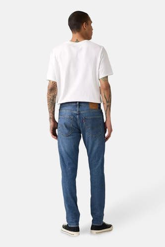 Blauwe jeans van denim, van Levi's, met een getailleerde pasvorm, gezien van achteren, gecombineerd met een wit T-shirt.