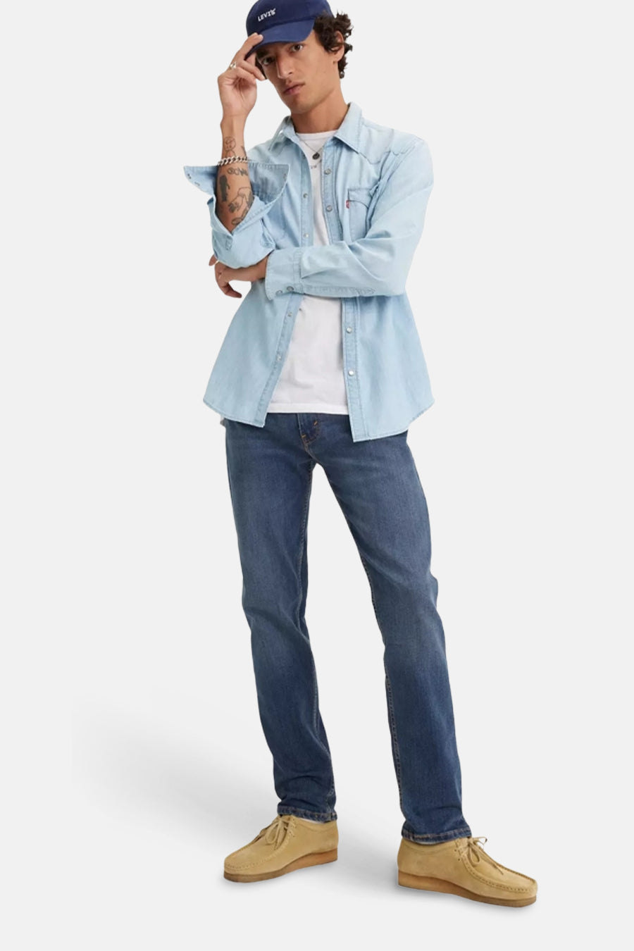 Blauwe tapered jeans van Levi's, met een lichtblauw overhemd en een wit T-shirt.