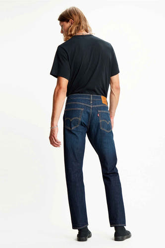 Donkerblauwe tapered jeans van Levi's, gezien van achteren, gecombineerd met een zwart T-shirt en zwarte schoenen.