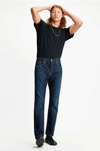 Donkerblauwe tapered jeans van Levi's, gedragen met een zwart T-shirt en zilveren ketting.