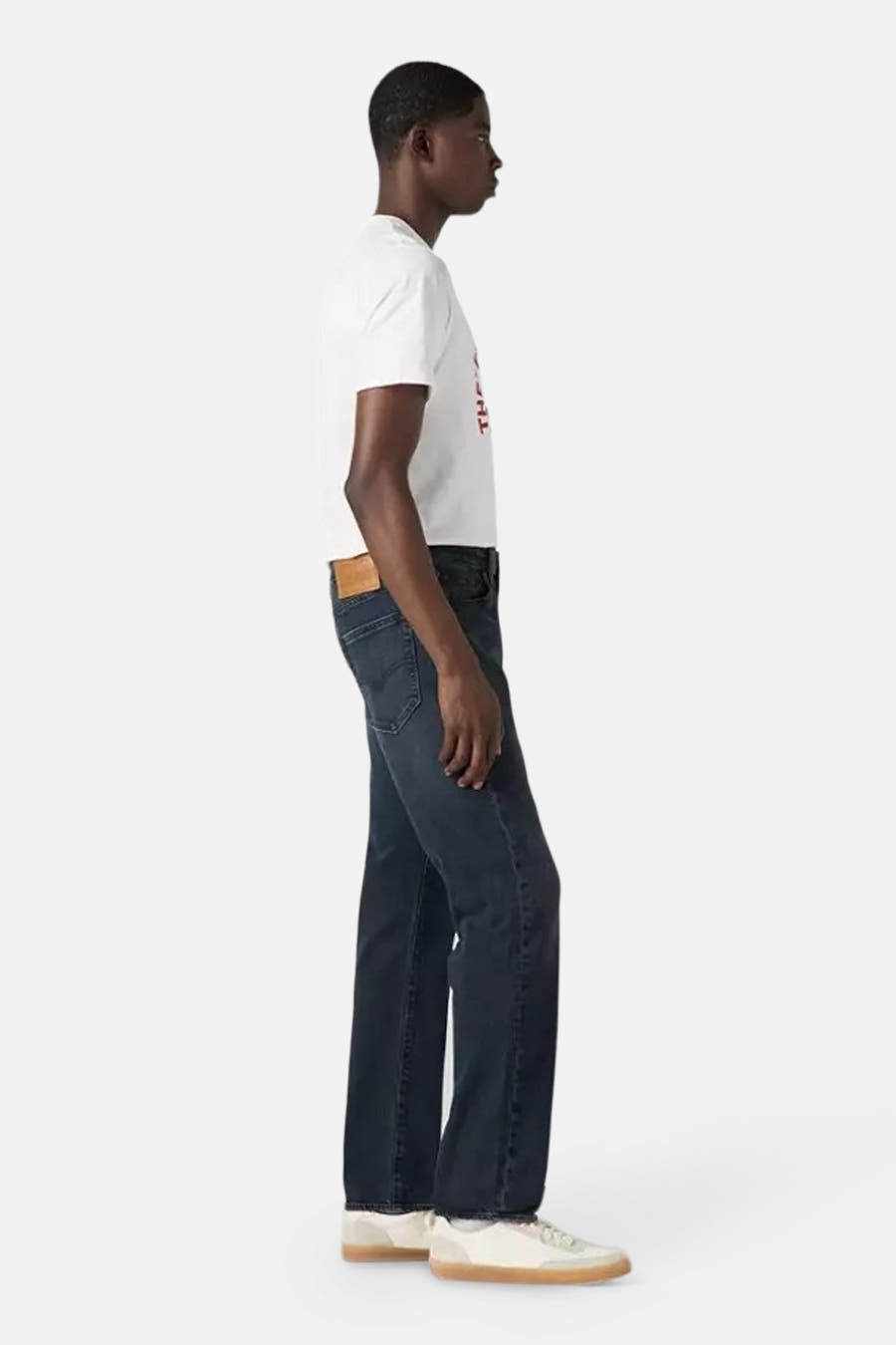 Tapered jeans van donkergrijs denim van Levi's®, gezien vanaf de zijkant, gecombineerd met een wit T-shirt.