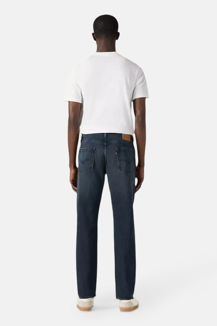 Tapered jeans van donkergrijs denim van Levi's, met een witte t-shirt en witte schoenen.