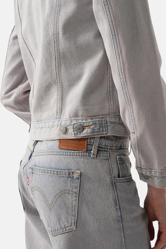 Jeansjas van lichtblauw denim van Levi's®, close-up achteraanzicht met jeans en rode labeldetails.
