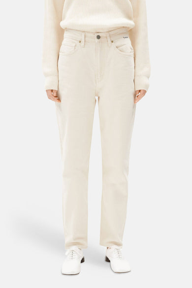 Off-white mom jeans van ARMED ANGELS, gecombineerd met een crèmekleurige trui en witte schoenen.
