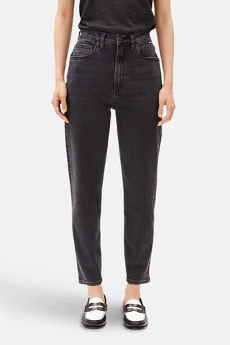 Donkergrijze mom jeans van ARMED ANGELS, met klassieke zakken en rechte pijpen, gecombineerd met zwarte en witte loafers.
