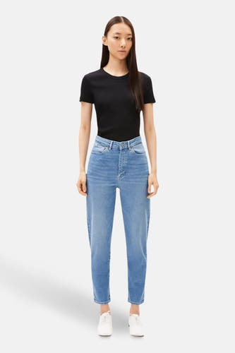 Middenblauwe mom jeans van ARMED ANGELS, gecombineerd met een zwart shirt en witte schoenen.