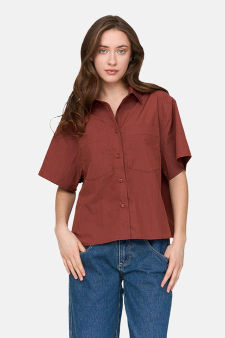 T-shirt rouge à manches courtes de 24 colours gmbh, avec col boutonné et poches, associé à un jean bleu.