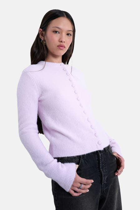 Roze cardigan van TOPSHOP, met lange mouwen en knoopsluiting, gecombineerd met een zwarte jeans.

