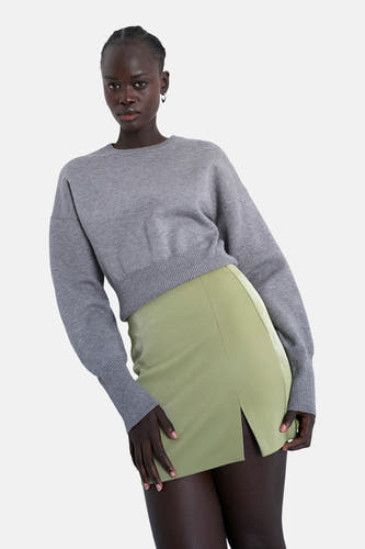 Groene korte rok van TOPSHOP, met een split en gedragen met een grijze trui.
