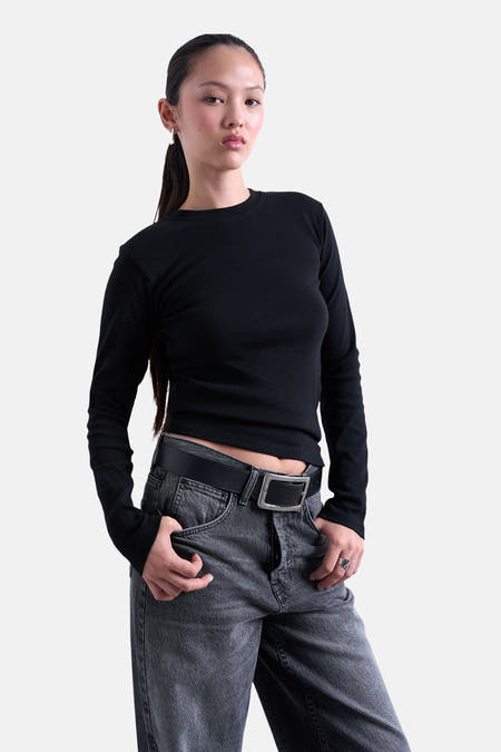 Zwart T-shirt met lange mouwen van TOPSHOP, gedragen met een grijze jeans met een riem.
