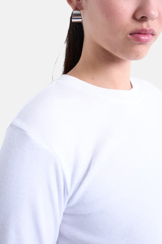 Wit T-shirt met lange mouwen van TOPSHOP, close-up van een model met zilverkleurige oorbellen.
