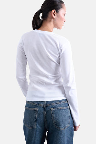 Wit T-shirt met lange mouwen van TOPSHOP, gezien van achteren, gecombineerd met een blauwe jeans.
