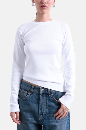 Wit T-shirt met lange mouwen van TOPSHOP, gedragen met een blauwe jeans en zilveren oorbellen.

