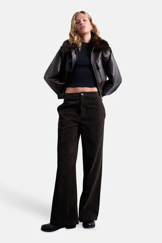 Zwart T-shirt met korte mouwen van TOPSHOP, gedragen met een bruine leren jas en donkerbruine corduroy broek.
