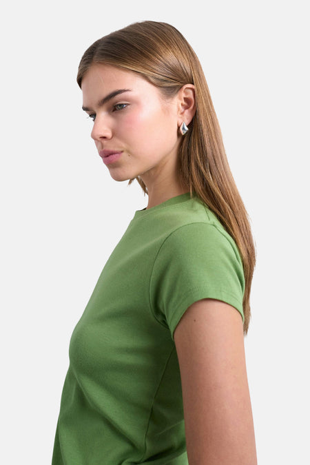 Groen T-shirt met korte mouwen van TOPSHOP, met een minimalistisch ontwerp en gladde textuur, gedragen door een model.
