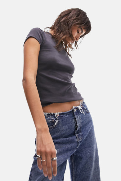 T-shirt gris à manches courtes de TOPSHOP, porté avec un jean déchiré et des détails froissés et des bagues d'argent.