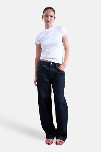 Wit T-shirt met korte mouwen van TOPSHOP, gedragen met een donkerblauwe jeans en rode sandalen.
