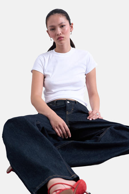 Wit T-shirt met korte mouwen van TOPSHOP, gedragen met donkere jeans en rode schoenen.