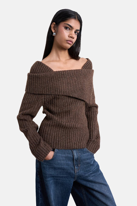 Bruine trui van TOPSHOP, met offshoulder halslijn, ribgebreide textuur, gecombineerd met een donkerblauwe jeans.
