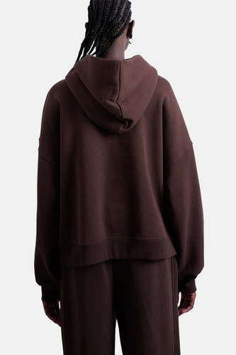 Bruine sweater met kap van TOPSHOP, gezien van achteren, met bijpassende joggingbroek en gevlochten haar.