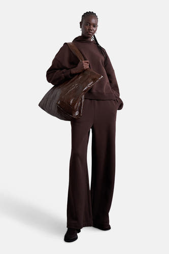 Bruine sweater met kap van TOPSHOP, gedragen met een bruine tas en wijde broek.
