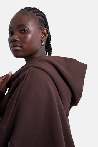 Bruine sweater met kap van TOPSHOP, met zilverkleurige oorbellen en gevlochten haar.