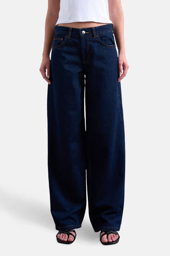 Jean bleu marine droit de TOPSHOP, avec des jambes larges et associé à un t-shirt blanc.