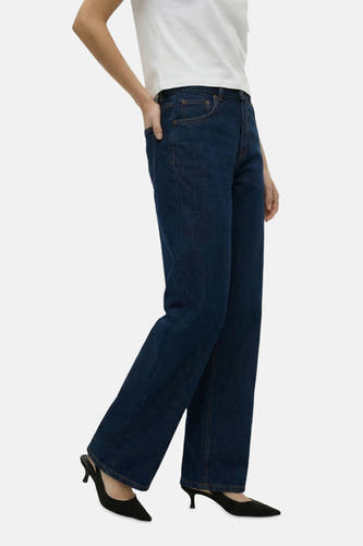 Donkerblauwe straight jeans van TOPSHOP, gecombineerd met een wit T-shirt en zwarte pumps.
