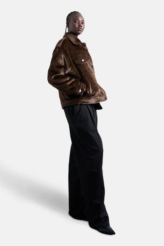 Manteau court brun de TOPSHOP, avec poches et boutons, associé à un pantalon noir et des chaussures noires pointues.