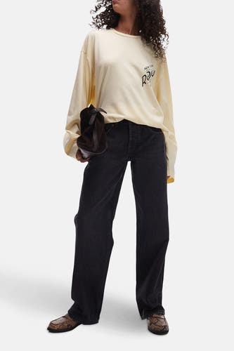 Zwarte wijde jeans van TOPSHOP, gecombineerd met een crèmekleurige top en bruine schoenen met slangenprint.
