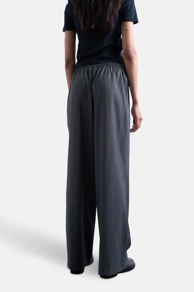 Grijze broek van TOPSHOP, gezien van achteren, met een elastische tailleband en losse pijpen.