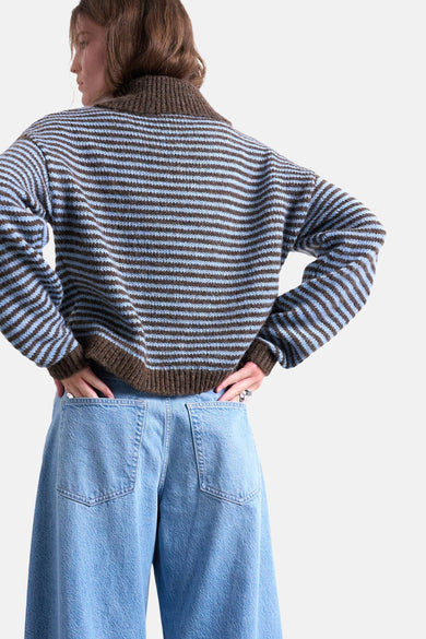 Multikleurige trui met ronde hals van TOPSHOP, met horizontale strepen en wijde blauwe jeans.
