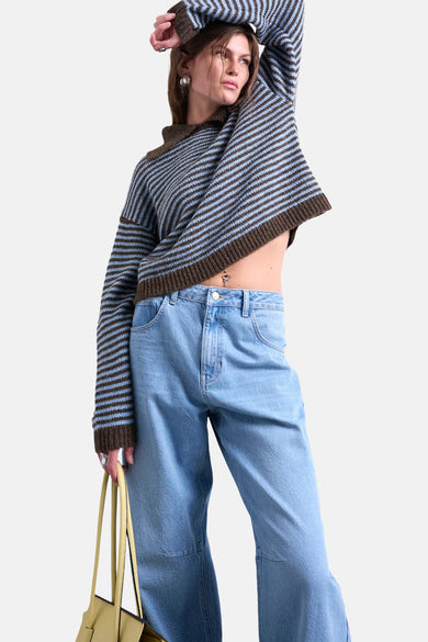 Multikleurige trui met ronde hals van TOPSHOP, met horizontale strepen en gecombineerd met blauwe jeans.
