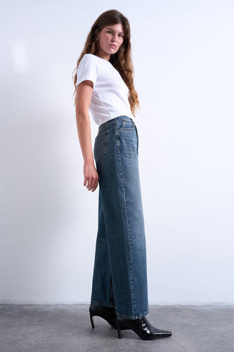 Jeans straight mid blue denim van TOPSHOP, gecombineerd met een wit T-shirt en zwarte laarsjes met hak.