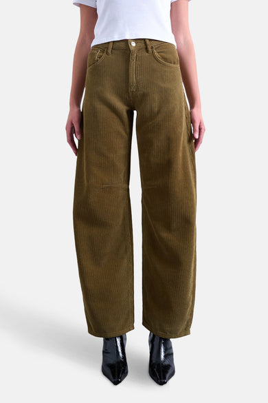 Bruine broek van TOPSHOP, gemaakt van ribstof, met wijde pijpen en zwarte laarzen.
