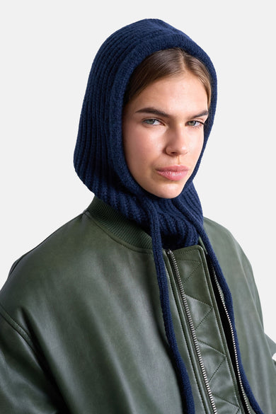 Blauwe hoed van TOPSHOP, gedragen met een groene leren jas met ritssluiting.