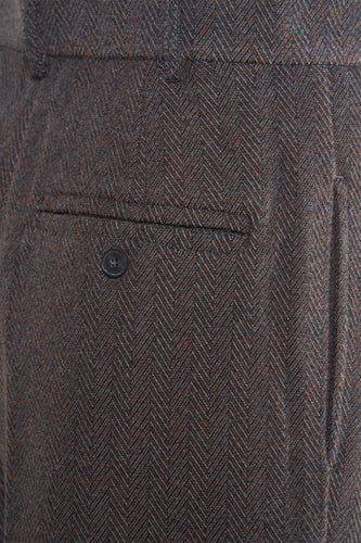 Bruine wollen broek met visgraatmotief en knoopzak.
