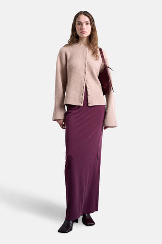 Lange rode rok van TOPSHOP, gecombineerd met een gebreid vestje en een bordeauxrode handtas.
