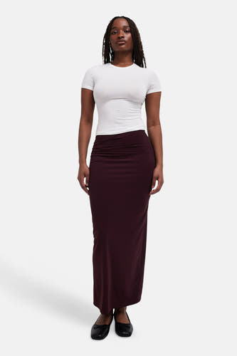 Lange rode rok van TOPSHOP, gecombineerd met een wit t-shirt en zwarte ballerina's.
