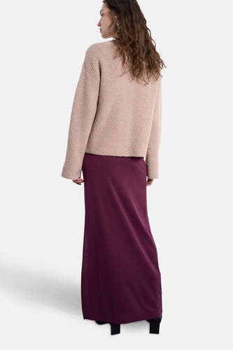 Lange rode rok van TOPSHOP, gecombineerd met een gebreide trui in een neutrale kleur, gezien van achteren.
