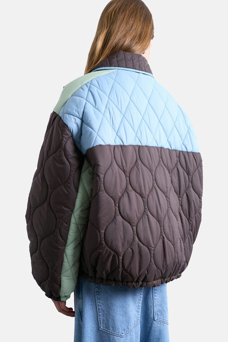 Bruine korte jas van TOPSHOP, met lichtblauwe details en een gewatteerd patroon, gezien van achteren.
