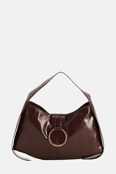 Sac à main brun de TOPSHOP, avec une bague dorée, associé à une blouse beige et à un pantalon large avec des talons hauts.